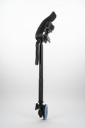 A black and gray camera rig with a suction cup, mounting bracket, and textured handle grip, photographed on a gray fabric background.